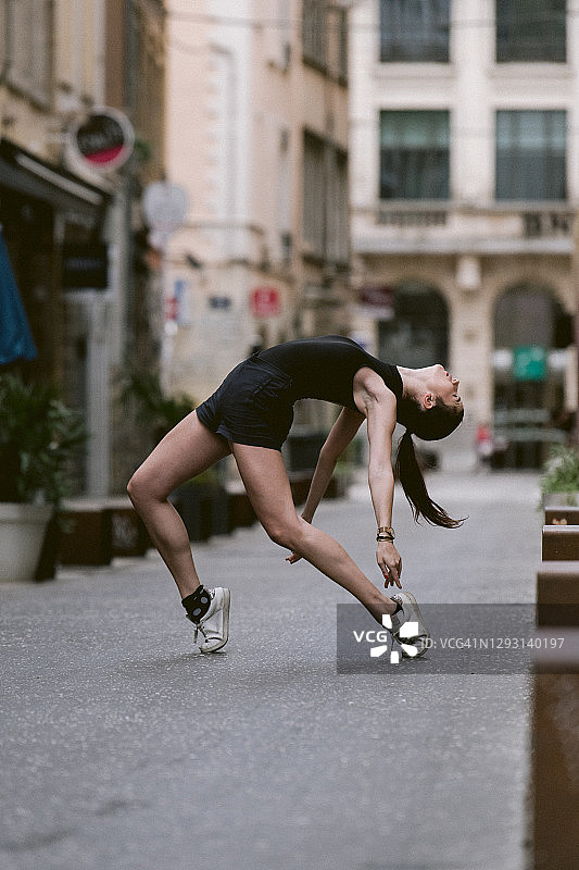 女芭蕾舞演员在法国里昂街头穿着短裤和运动鞋跳舞和训练图片素材
