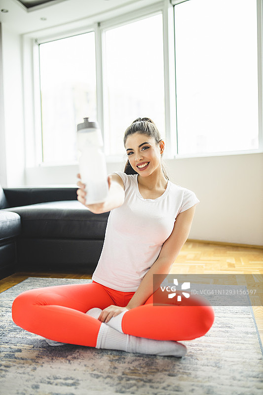 女人在家锻炼后喝水放松图片素材