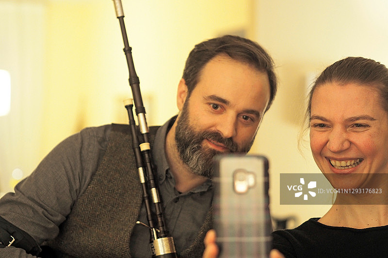 情侣笑着看智能手机图片素材