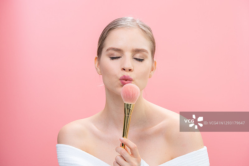 年轻女子涂抹粉底图片素材