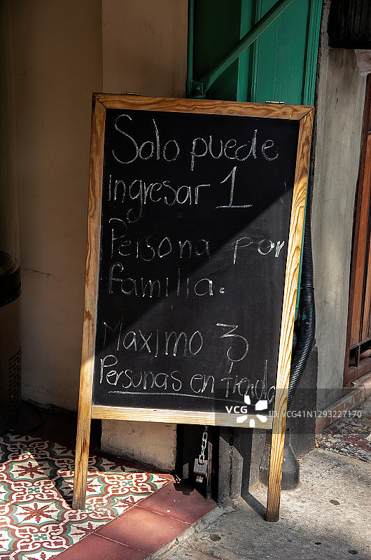 商店外写有西班牙语covid-19健康和安全建议的黑板图片素材