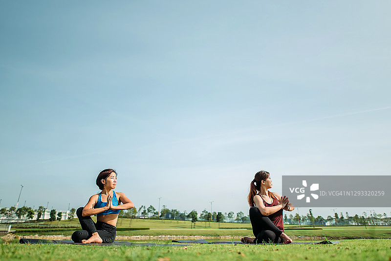 两位美丽的中国女性在公园湖边练习瑜伽图片素材