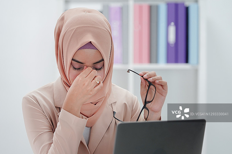 压力大的穆斯林女商人在办公室工作时感觉不适疲惫图片素材