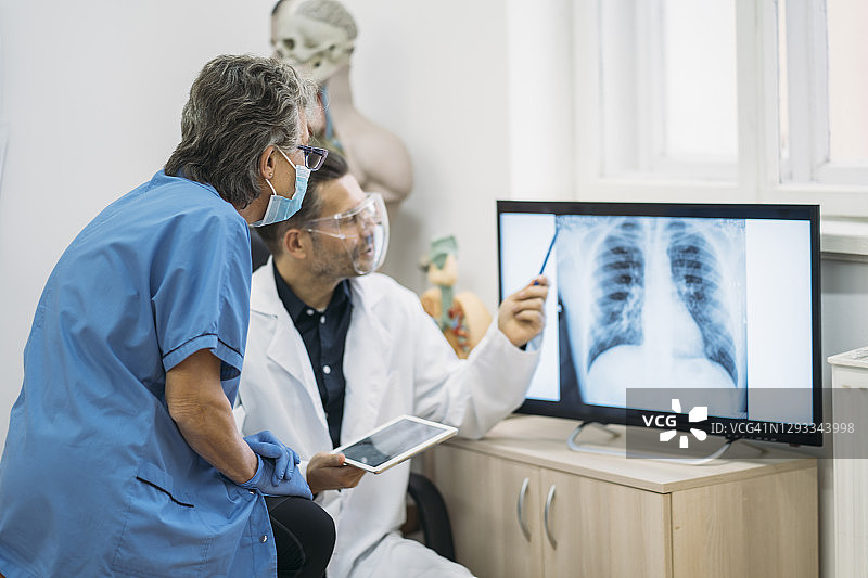 男医生和护士查看肺部X光片图片素材
