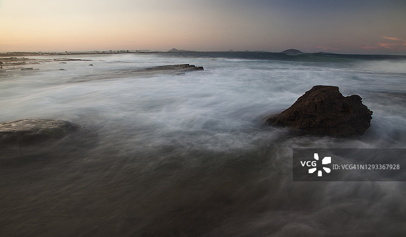 黄昏时分，阳光海岸卡特赖特角岩石架上，海浪围绕岩石旋转的空灵效果慢速快门，澳大利亚昆士兰州图片素材