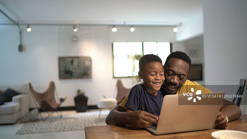 父亲帮助儿子在家学习图片素材