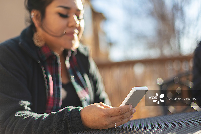 使用智能手机的美洲原住民Z世代女性图片素材