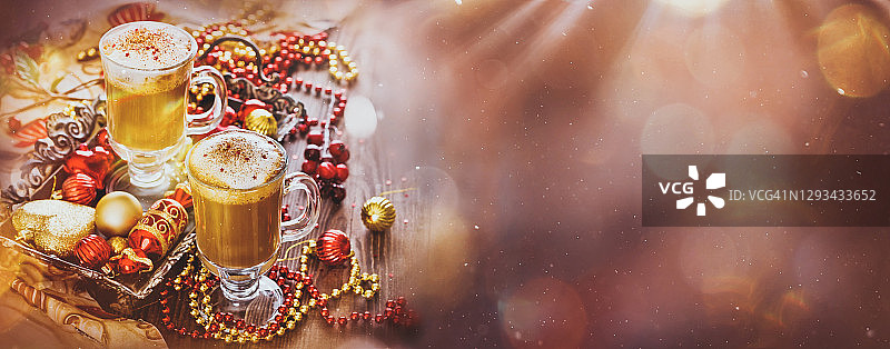 圣诞贺卡，木制背景上的两杯热咖啡或卡布奇诺与圣诞装饰品图片素材