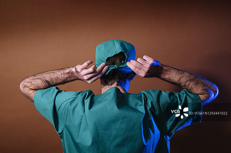 身份不明的女医生戴上绿色帽子图片素材