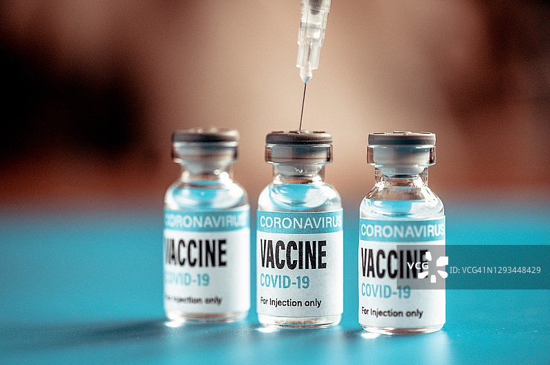 新冠疫苗：绿色背景上的注射器和药瓶图片素材