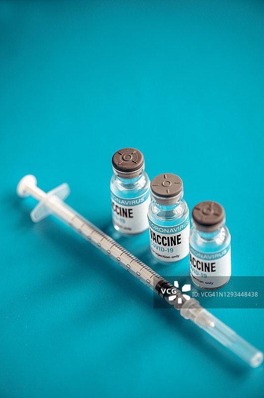 新冠疫苗：绿色背景上的注射器和药瓶图片素材