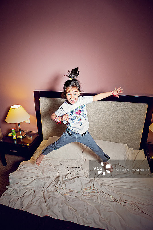 在卧室里唱歌跳舞的快乐小女孩图片素材