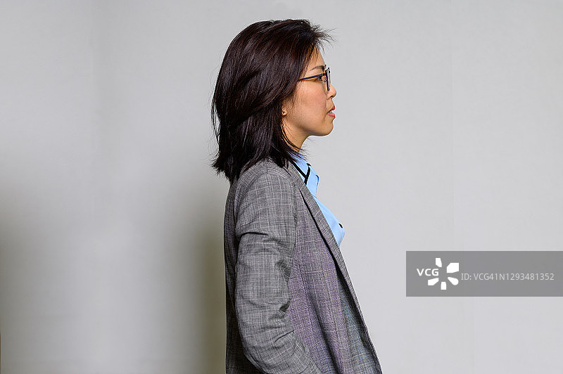 站立直视的亚洲美丽商务女性侧面肖像图片素材