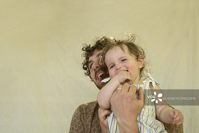 和宝宝在一起的年轻父亲的滑稽肖像图片素材