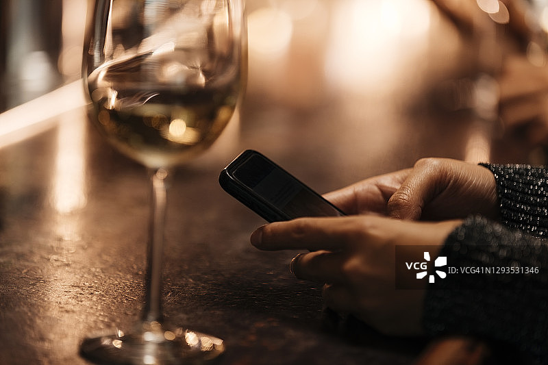 女子在吧台使用手机的裁剪图图片素材