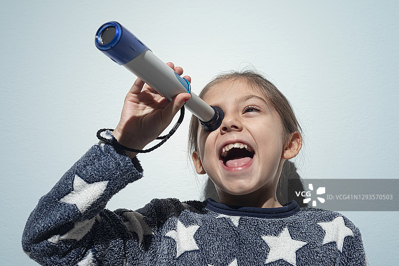 小女孩用望远镜观察图片素材