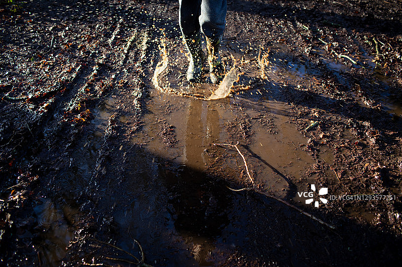 男孩在泥坑里跳跃图片素材