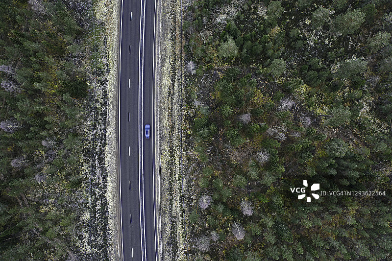 在穿过森林的高速公路上行驶的汽车图片素材
