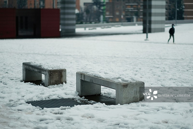 清晨米兰的雪景：市中心广场与混凝土长椅图片素材