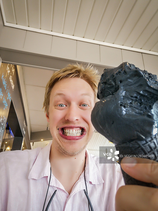 年轻人在挪威埃兹沃尔德品尝黑色冰淇淋图片素材