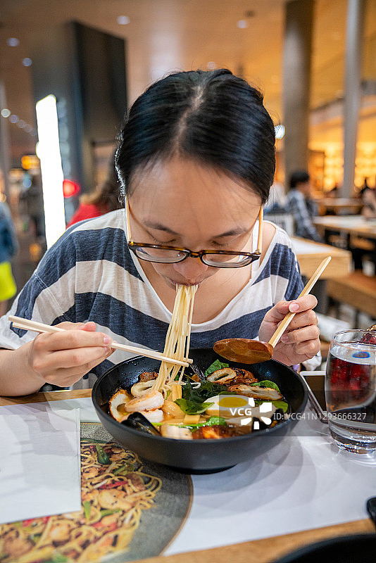 年轻女人在挪威加勒穆恩品尝亚洲美食图片素材