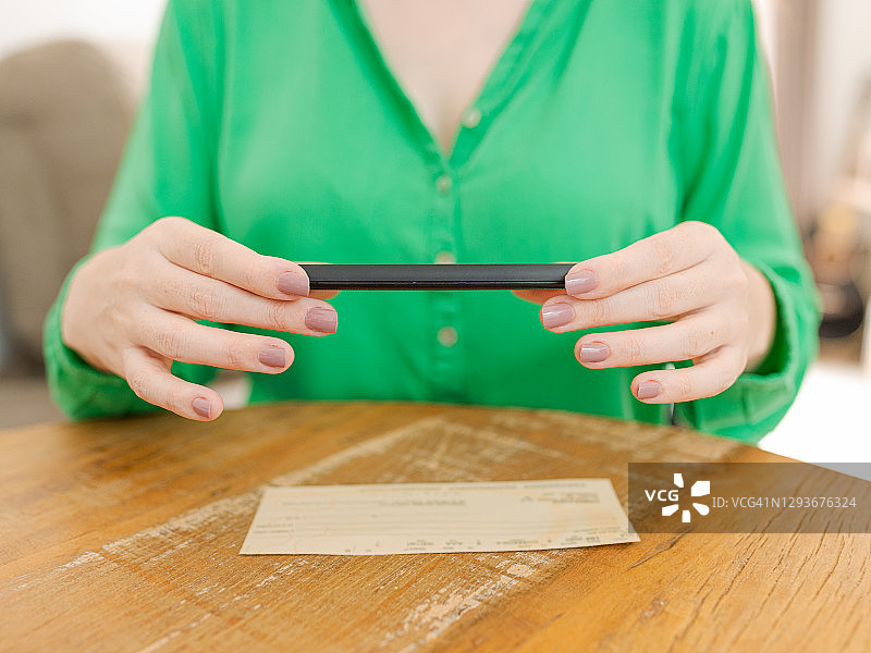 女人拍照进行远程存款的细节图片素材