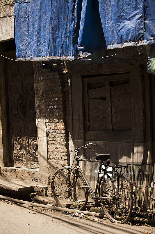 旧自行车停在加德满都泰米尔的雕花老建筑前图片素材