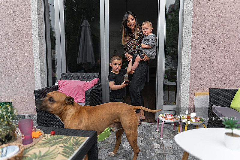 后院里和狗玩耍的家庭图片素材