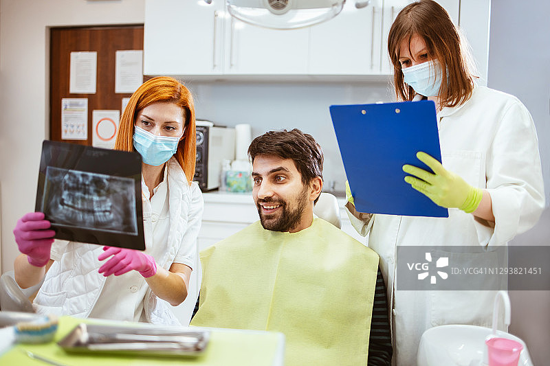 女牙医和一位助手正在观察X光片图片素材