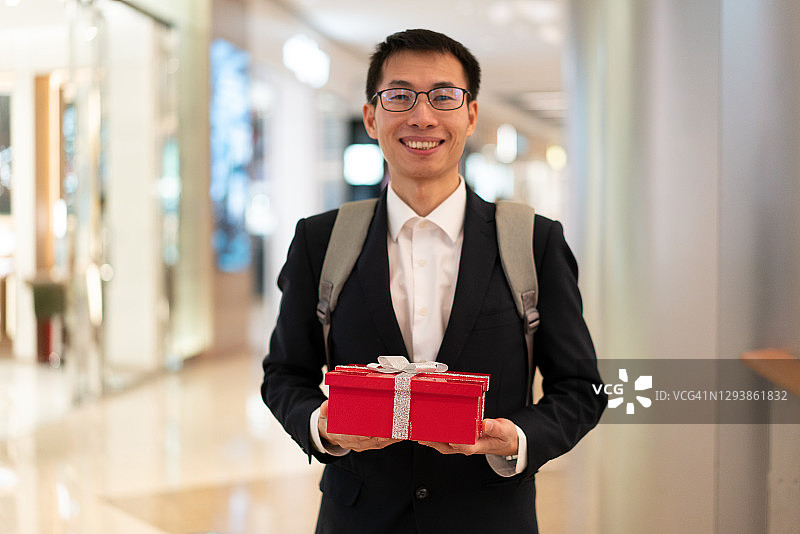 拿着礼品盒的亚洲男人图片素材