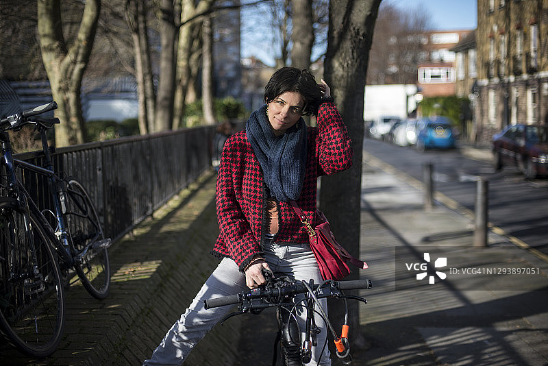 在伦敦东区街道上骑自行车的女人图片素材
