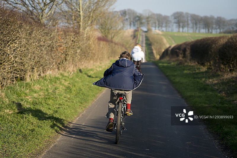 儿童在英国乡村小路上骑自行车图片素材