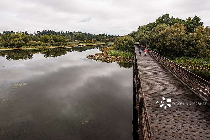 老夫妇骑自行车通过旧栈桥图片素材