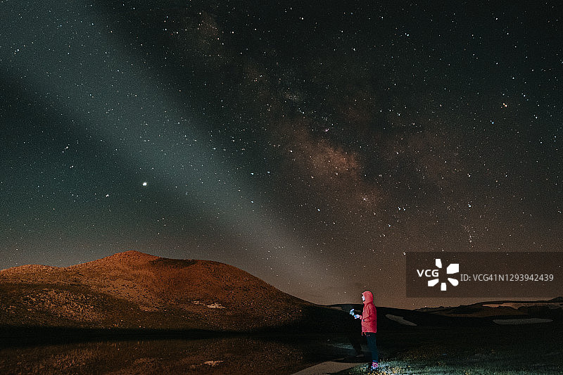 男游客在营地篝火旁欣赏星空夜景图片素材