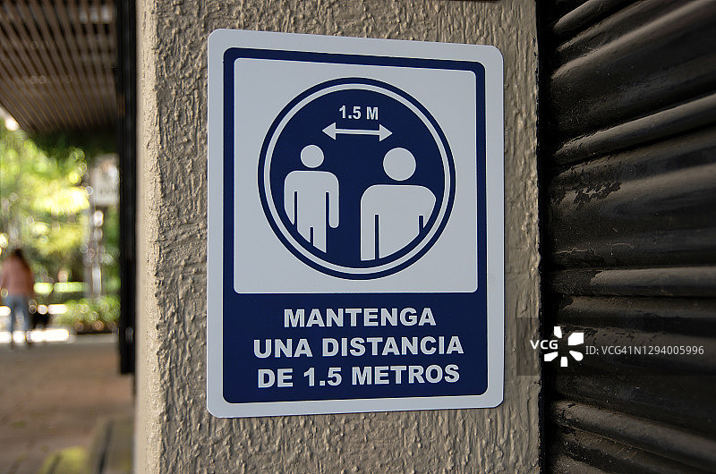 小型商店入口处的西班牙语COVID-19健康和安全标牌图片素材