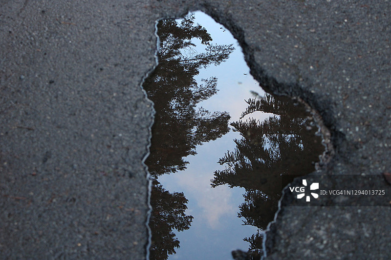 破损路面水坑中的倒影图片素材