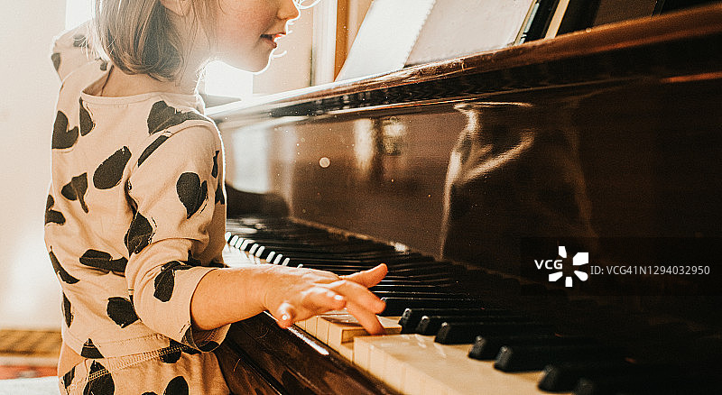 快乐的小女孩轻松弹奏大钢琴图片素材