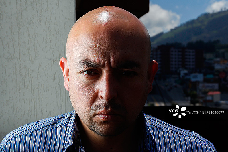 厄瓜多尔基多市背景下，面部半隐于阴影中的自信专注男人肖像图片素材