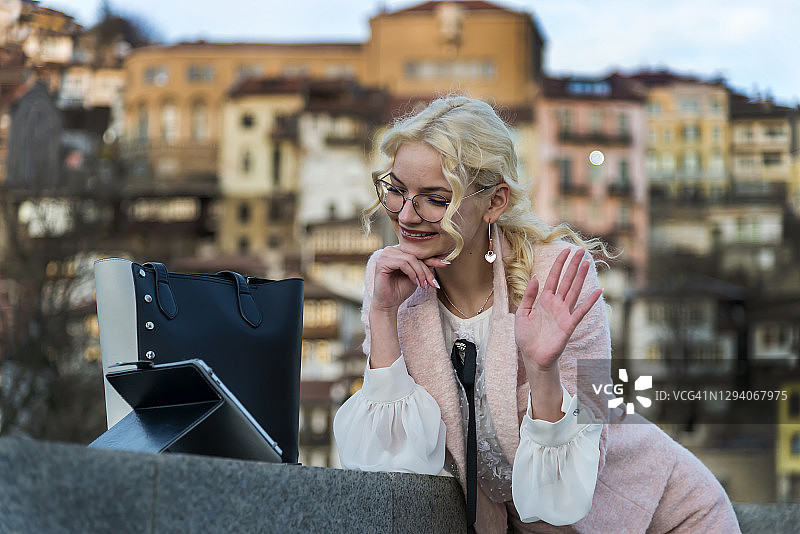 在办公室露台上进行电话会议的年轻女商人图片素材