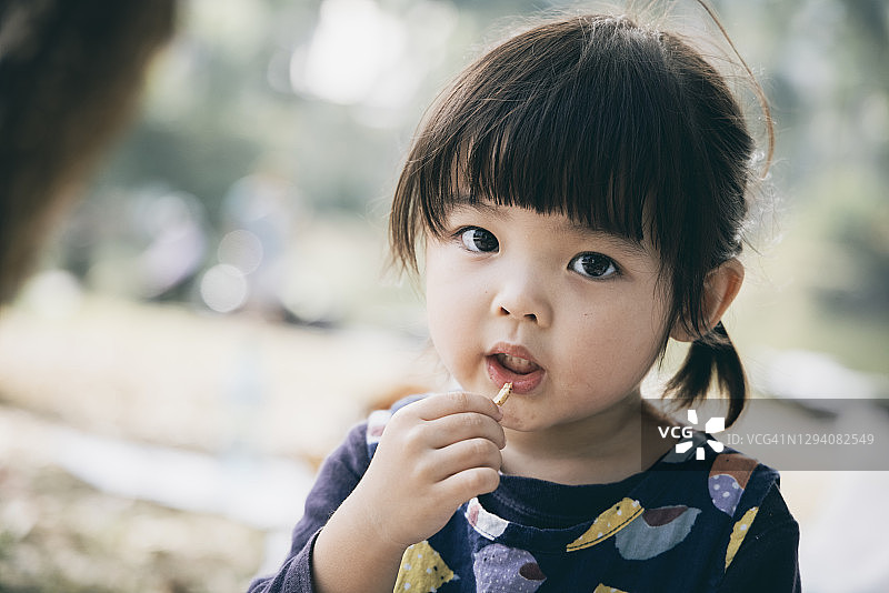 在公园里享用早餐和野餐的可爱中国女孩图片素材