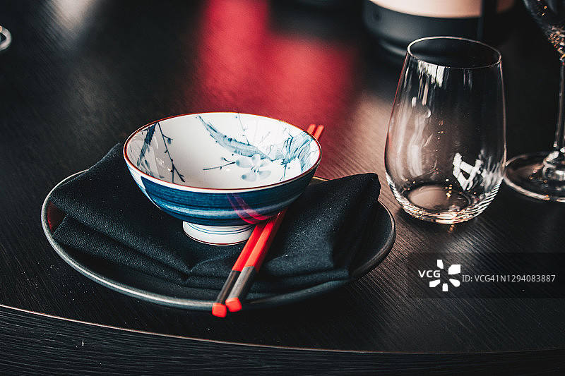 现代优雅亚洲餐厅中，盘子上的碗和筷子图片素材
