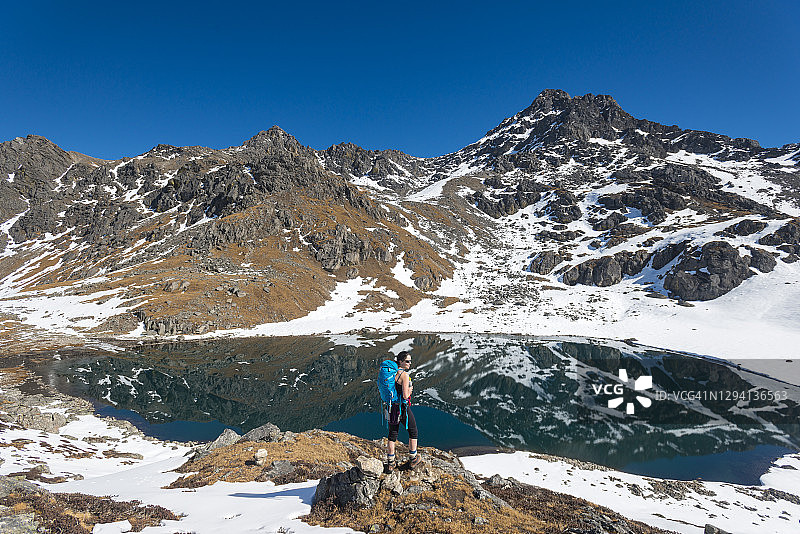 在尼泊尔朗塘地区，一位女子走过戈赛因昆达圣湖图片素材