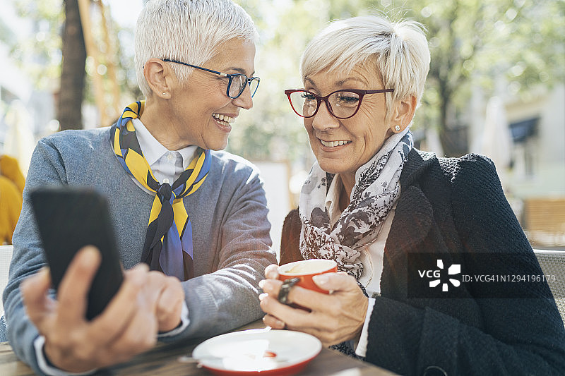 中年女性朋友使用智能手机图片素材