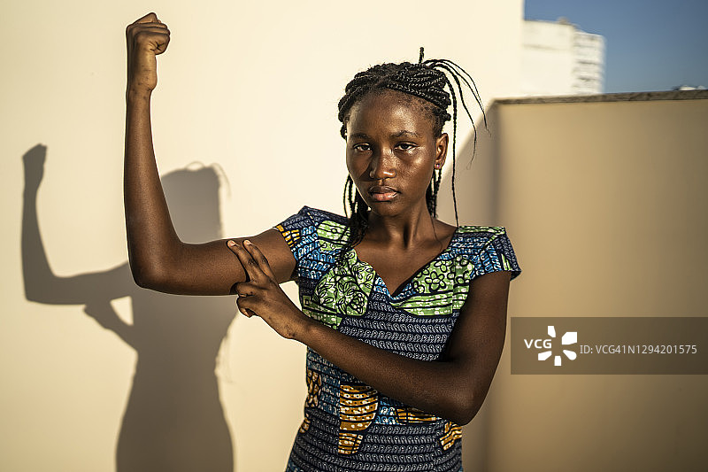 身着传统服饰的非洲女人指着她的手臂图片素材