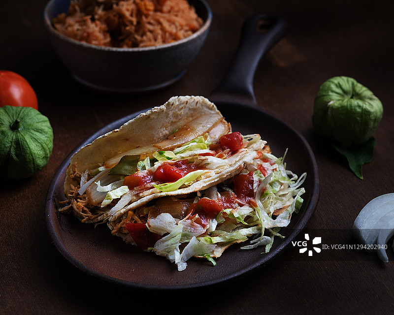 深色背景下的鸡肉 Taco 配新鲜食材图片素材