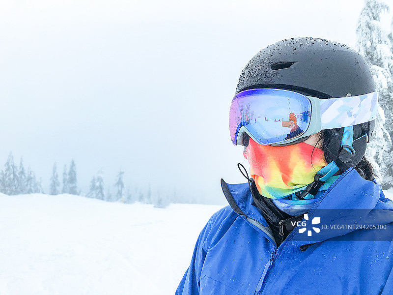 一位戴着头盔、护目镜和脖套的不知名年轻女滑雪者图片素材
