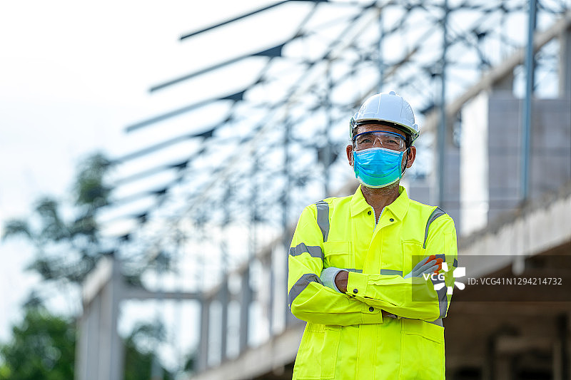 在建筑工地工作时佩戴防护口罩的建筑工人图片素材