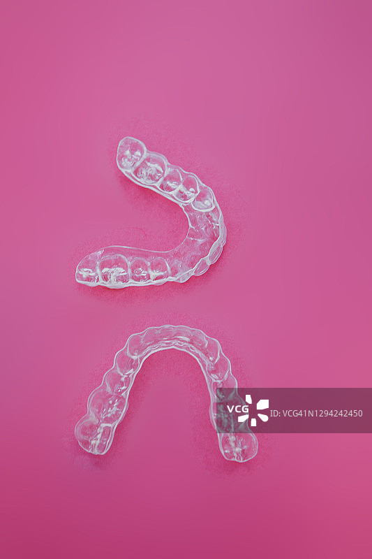粉色背景中带有闪光彩带的隐形保持器和正畸托槽的扁平风格图像图片素材