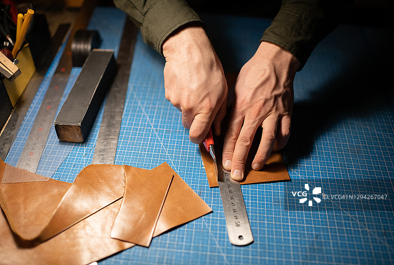 工匠在桌子上裁剪皮革图片素材