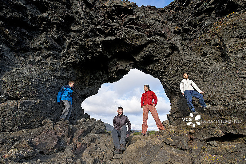 一家人在冰岛米湖的天然石拱门前合影图片素材